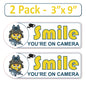 2 Pack 3"x9" Laminated Vinyl Funny Angry Face "Smile You're On Camera" Video Surveillance Labels Stickers Sign Decals Security Sign for Home, Business, Cars, Windows, and CCTV Systems